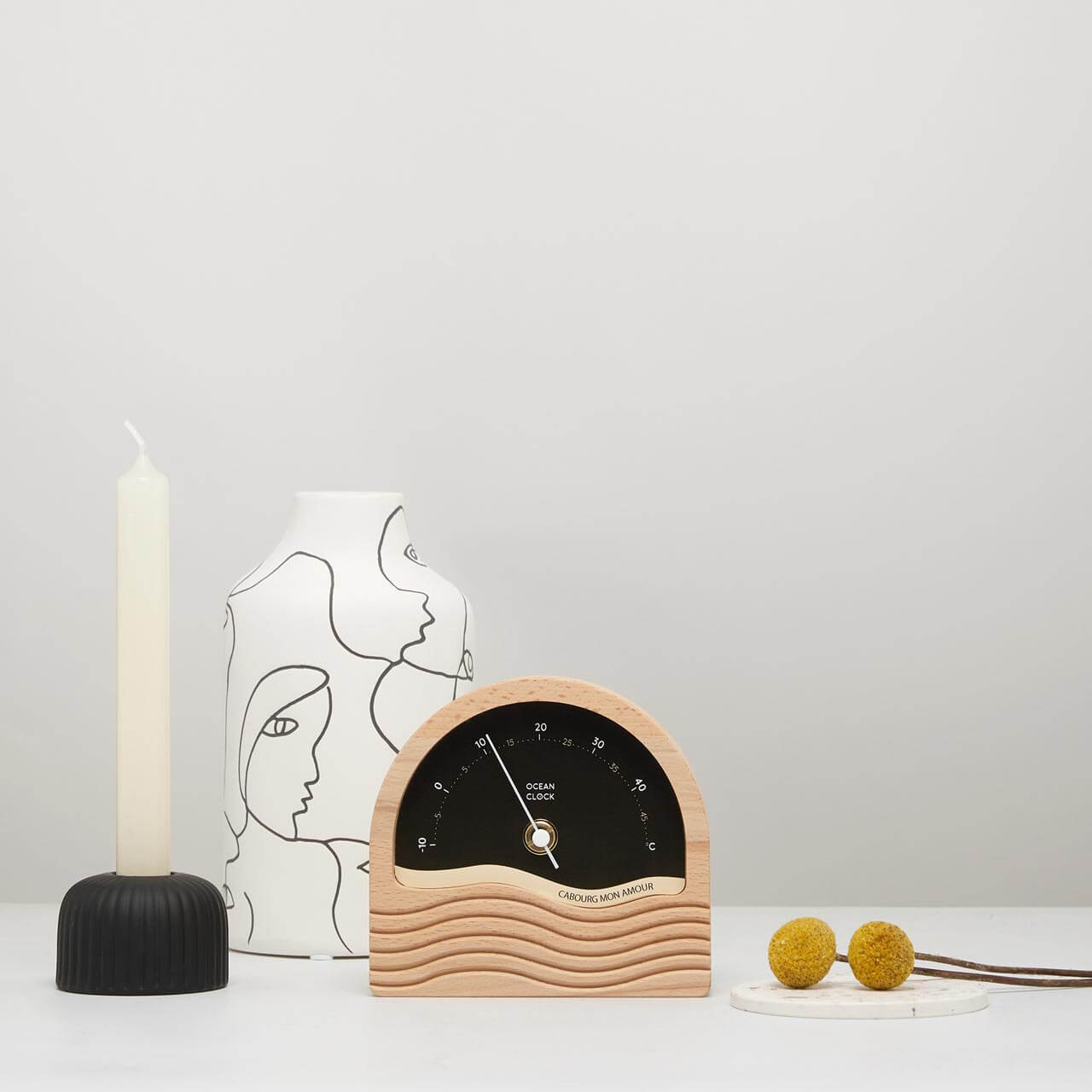 wooden thermometer with personalised black dial and vase and candle around it