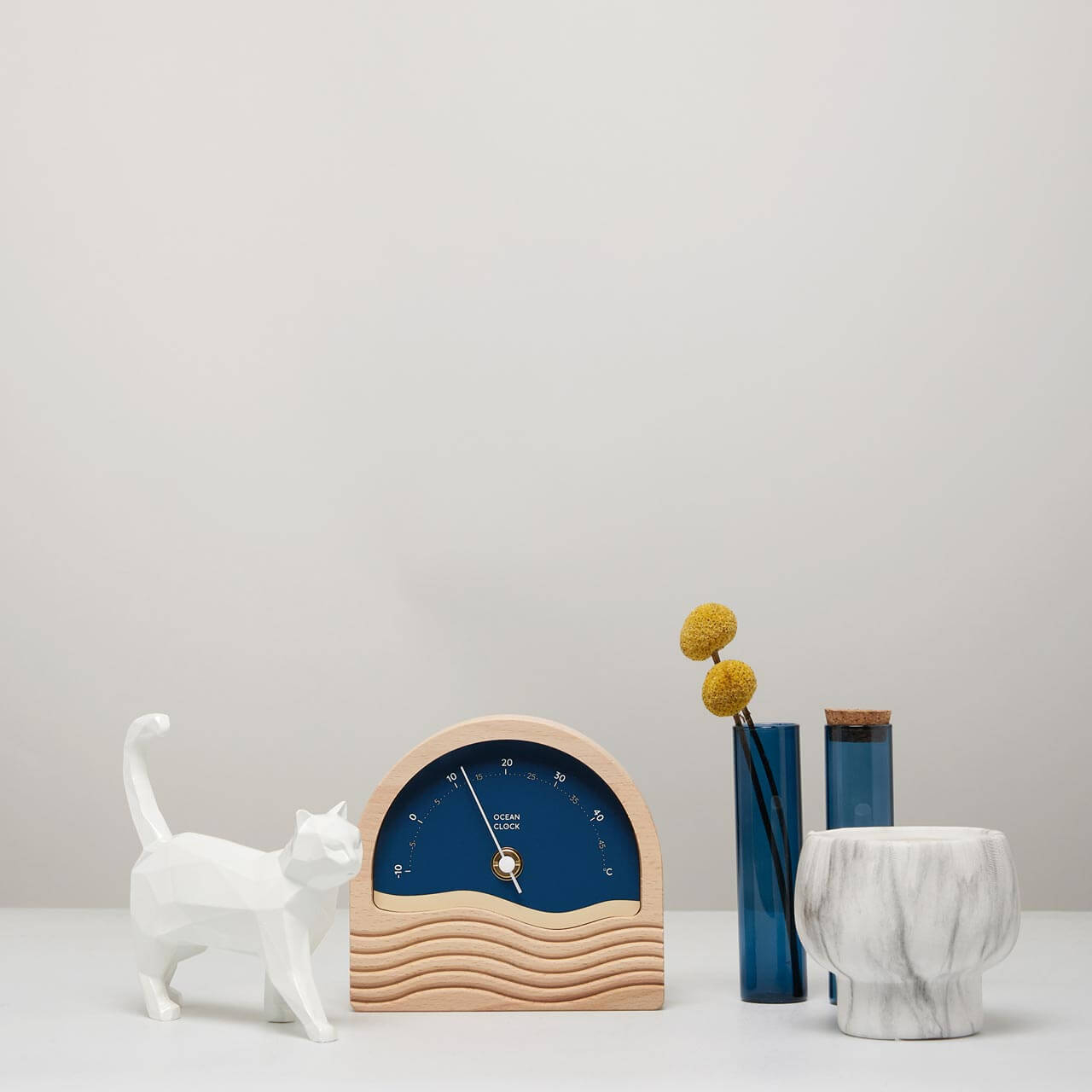 thermomètre celsius en bois avec cadran bleu marine posé sur table