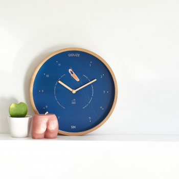 horloge bleu avec une surfeuse à côté d'une bougie